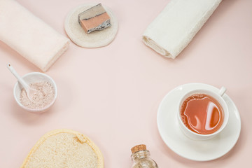 Creative flat lay of bath accessories beauty spa concept with copy space handmade soap rose and clay mask top view cup of tea