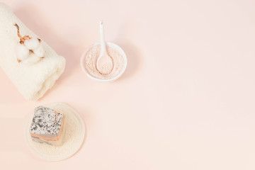 Spa beauty skin care minimal concept creative  lay out composition made of clay and rose cleansing mask handmade soap cotton flower soft towel pink background with copy space top view