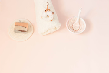 Spa beauty skin care minimal concept creative  lay out composition made of clay and rose cleansing mask handmade soap cotton flower soft towel pink background with copy space top view