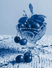 Cherries in the beautiful crystal vase on the lace tablecloth - 308305959