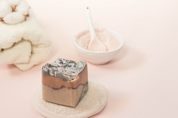 Spa beauty skin care minimal concept creative  lay out composition made of clay and rose cleansing mask handmade soap cotton flower soft towel pink background with copy space top view