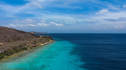 Fototapeta na wymiar Aerial view of coast of Curaçao in the Caribbean Sea with turquoise water, cliff, beach and beautiful coral reef around St.Martha Bay