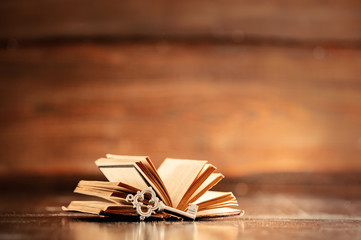 Old book and key on wooden table
