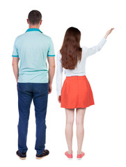 Back view of a stylish couple pointing.