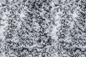 Asphalt covered with ice background texture close-up.