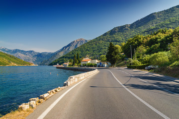 Sunny morning view of Kotor bay and coastal road near Tivat, Montenegro.