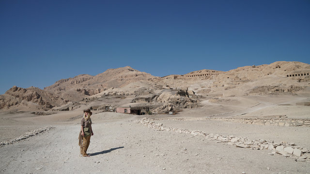 Panoramafoto: blonde Frau als Tourist vor dem Dorf der Grabr&auml;uber el-Qurna in den thebanischen Bergen in Luxor, &Auml;gypten