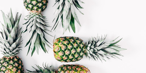 Obraz premium Pineapple minimal pattern. Border made of pineapples on white background. Summer concept. Flat lay, top view, copy space