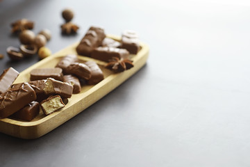 Chocolate bars on a black background in backlight. Chocolate with filling. Sweet sweets for snack and tea.