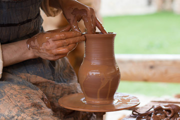 hands of potter making jugs