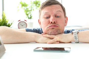 Man with funny facial expression staring at cellphone