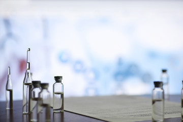 A man signs a medical document. Medical equipment on the table. Stethoscope and ampoules with syringes. Makes notes in the office. Medical center.