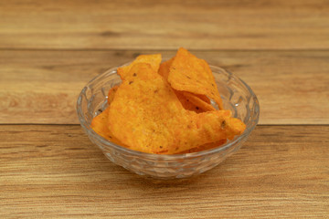 Plate with tasty nachos with wooden background