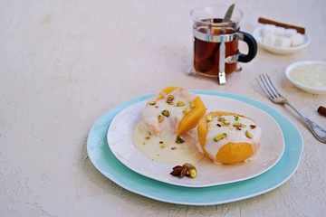 Dessert of stewed quince in syrup, poured with custard on a white plate on a light concrete background. Healthy desserts. Turkish cuisine.