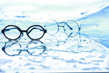 Tools for vision correction. Glasses and lenses with diopters on the background of splashes and...