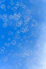 Soap bubbles against blurred blue sky background