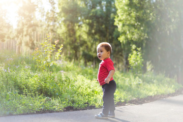 portrait of smiling little boy on the street. cute cheerful baby walking in the Park. happy child