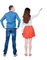 Back view of a stylish couple pointing.