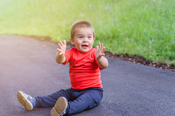 portrait of smiling little boy on the street. cute cheerful baby walking in the Park. happy child