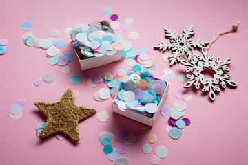 Pink background with christmas decorations and colourful confetti