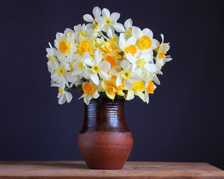 yellow daffodils in a clay jug