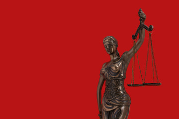 Lady Justice statue is the Greek ancient goddess Themis a symbol of justice isolated on red