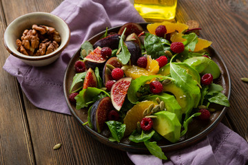 Healthy salad with avocado and oranges, figs