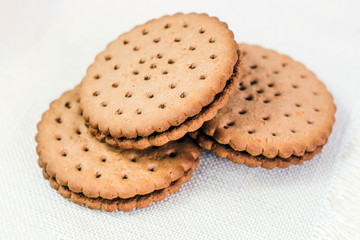 Crispy chocolate chip cookie with holes on the table. Filled Round Cookies