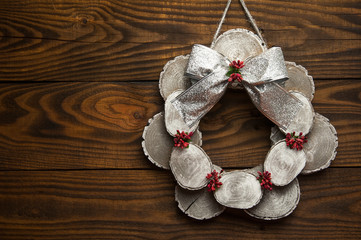 Christmas wreath with a big bow on a door or Christmas tree. Christmas attributes on wooden background.