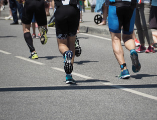 Group of young running athletes in jogging shoes on sport track