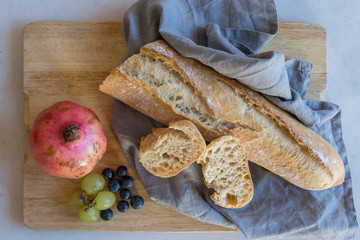 Top view of a wooden tray with bread and fruits