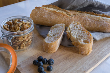 Side view of a wooden tray with bread, nuts and fruits