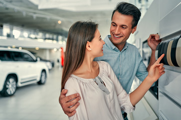 Young couple choosing interior color for their brand new car.