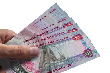 Obraz premium Hand holding dirhams of United Arab Emiratess. AED. Currency of UAE