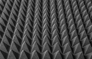 Abstract background in the form of pyramids and dragon scales. Acoustic black foam rubber.