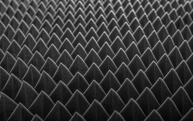 Abstract background in the form of pyramids and dragon scales. Acoustic black foam rubber.