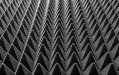 Abstract background in the form of pyramids and dragon scales. Acoustic black foam rubber.