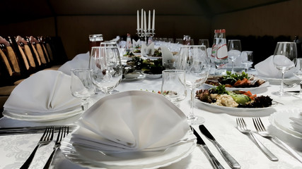 Cutlery and cold cuts served on a festive table in restaurant. Serving, celebration, wedding and anniversary concept.