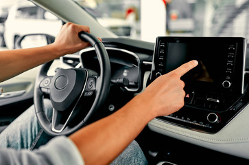 Cropped image hand of man using navigation system or dashboard while driving a car.