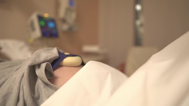 Labor Ward Using Cardiotocography Monitor To Record Fetal Heartbeat And Uterine Contractions During Pregnancy - Closeup Shot