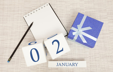 Calendar with trendy blue text and numbers for January 2 and a gift in a box.
