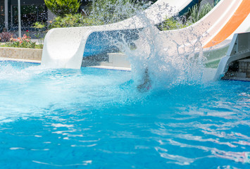 Children enjoying in pool water slide at pool