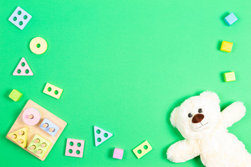 Baby kid toys background. Teddy bear and wooden pastel color geometry educational toy for children on light green background