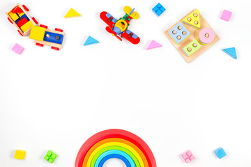 Baby kids toys background. Wooden educational geometric stacking blocks toy, rainbow, airplane, train and colorful blocks on white background. Top view, flat lay