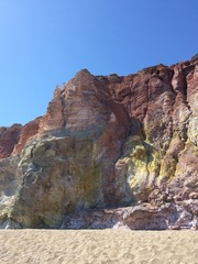 Volcanic red and yellow cliff rocks in Milos, Greece