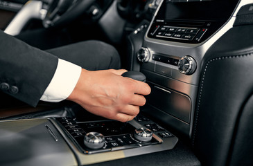 Car Driving Concept. Driver Shifting To Drive Mode. Hand on Transmission Stick Closeup