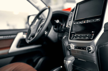 Luxury car interior. Steering wheel, shift lever and dashboard.