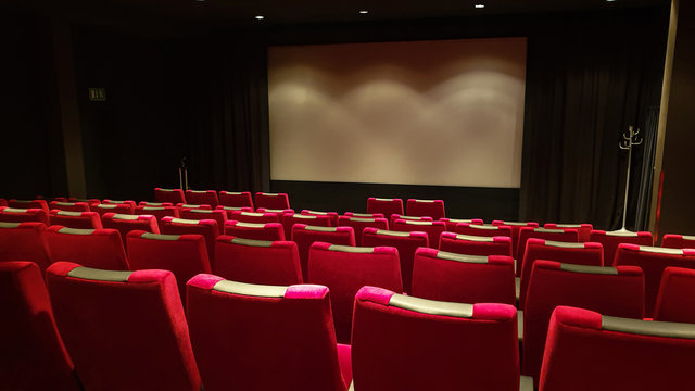 Empty cinema hall, cinema screen and row of red sits