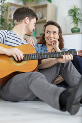 Fototapeta premium couple relaxing in the home man playing guitar