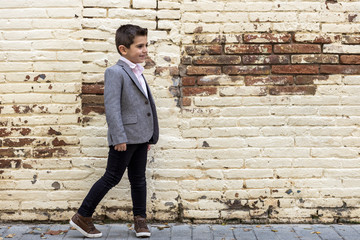 Fashion little kid with a brick wall background